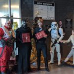 Costumed Star Wars fans standing in front of a Christmas tree